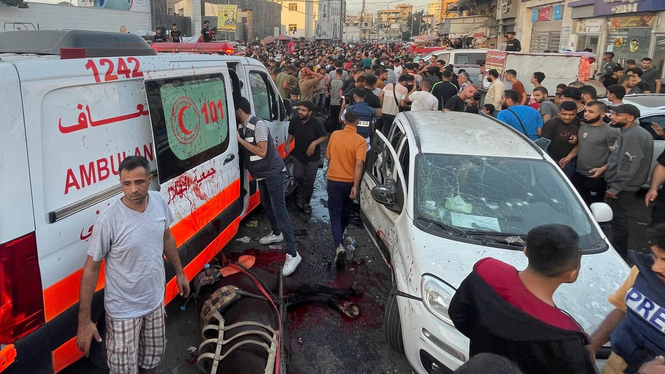 Mehrere Menschen stehen um einen Krankenwagen, der bei einem israelischen Luftangriff getroffen wurde.