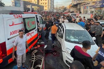 Mehrere Menschen stehen um einen Krankenwagen, der bei einem israelischen Luftangriff getroffen wurde.