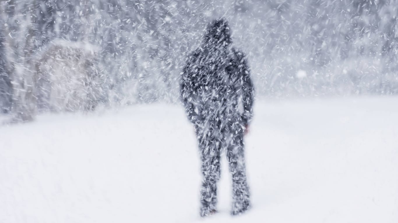 Ein Mann steht im Schneegestöber (Archivbild): In Baden-Württemberg soll es in den kommenden Tagen schneien.