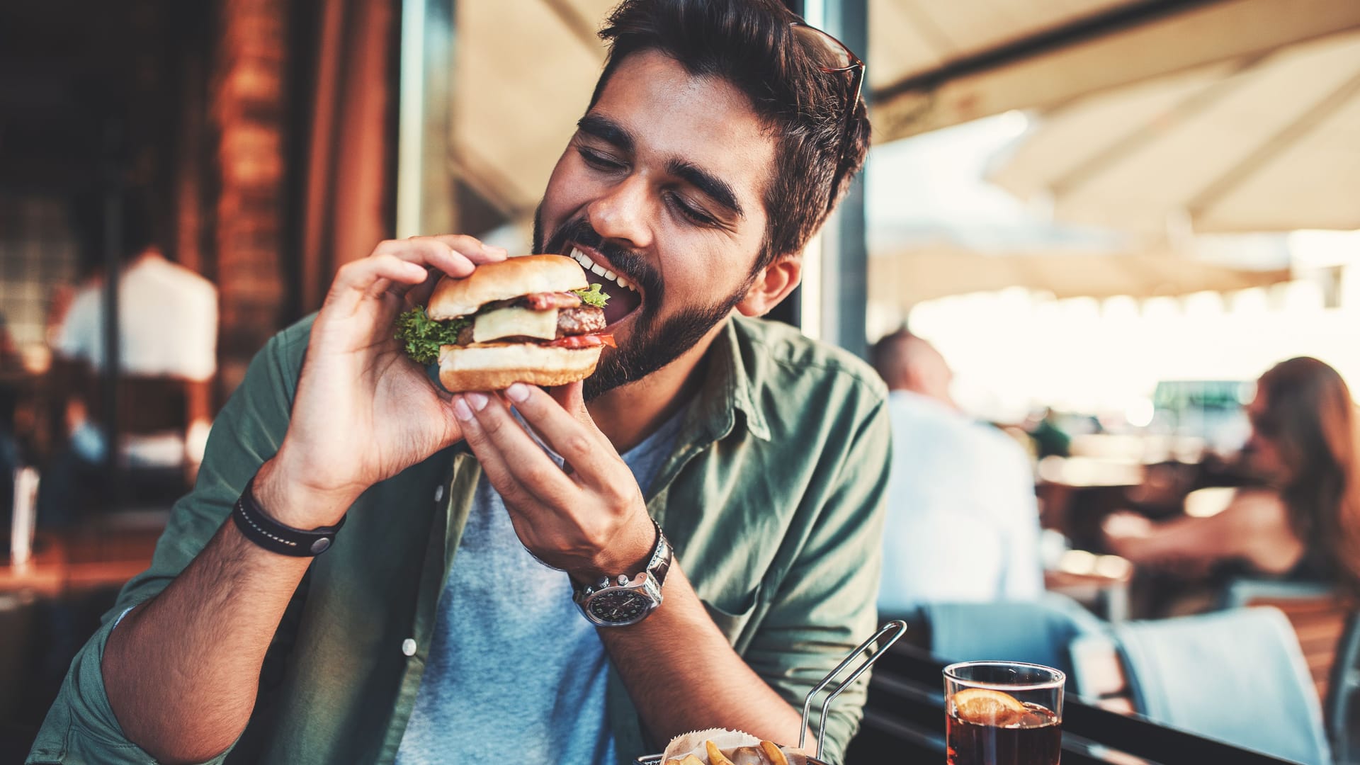 Ein Mann beißt in einen Burger