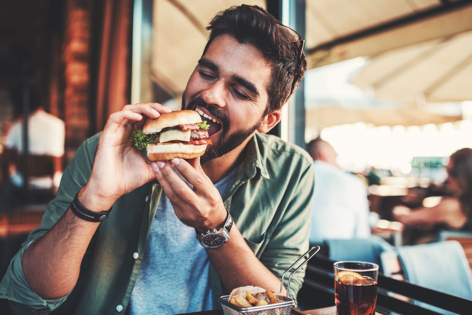 Ein Mann beißt in einen Burger