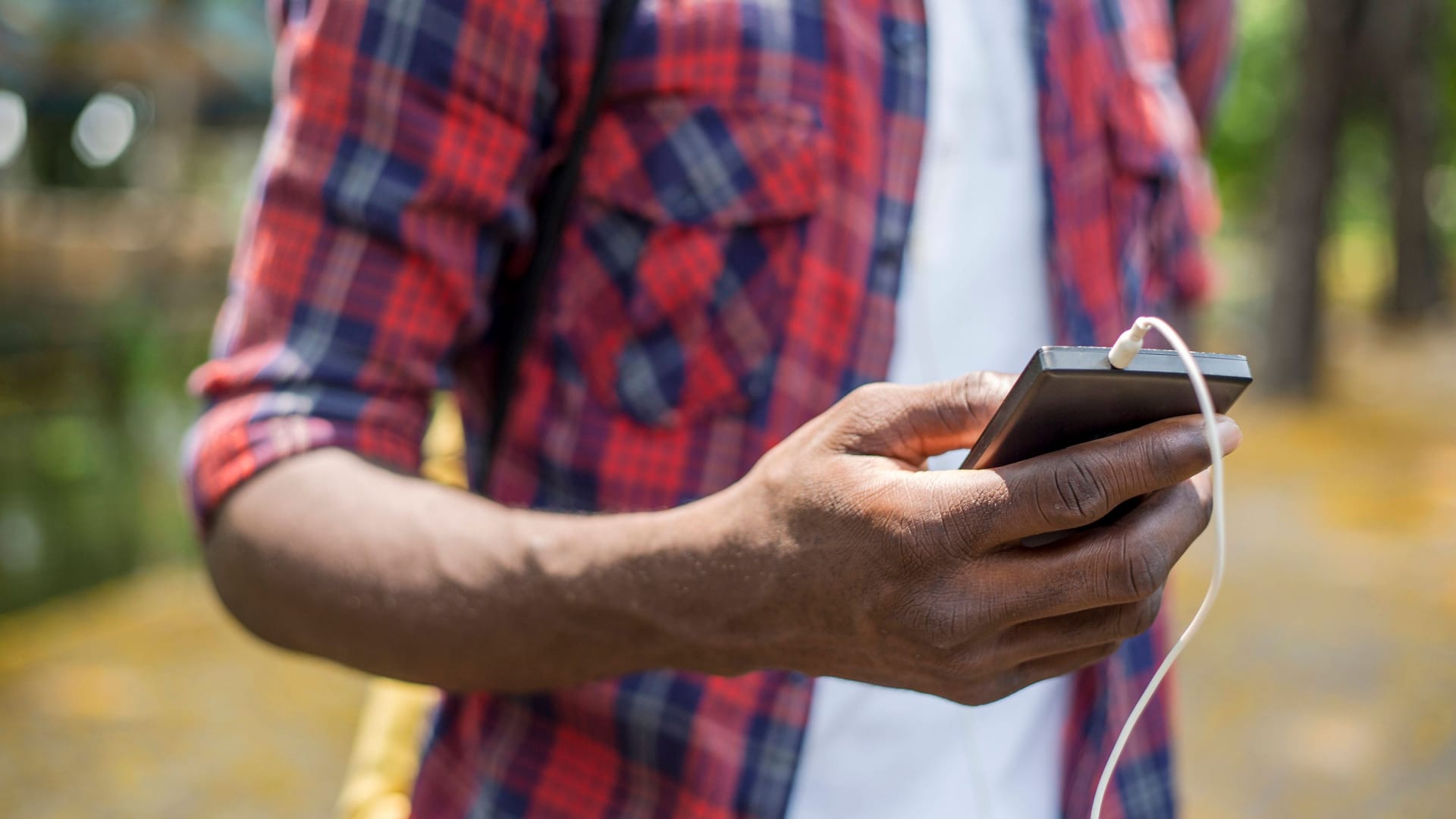 Mann blickt auf ein Smartphone (Symbolfoto): In Troisdorf sorgt das Netzvideo eines Teenagers für Aufsehen.