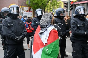 ARCHIV - Eine Frau trägt eine Palästina-Flagge.
