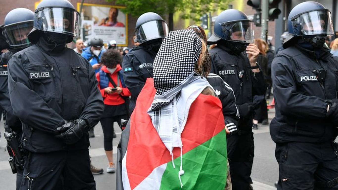 ARCHIV - Eine Frau trägt eine Palästina-Flagge.