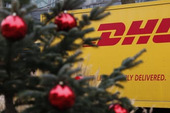 Ein DHL-Transporter hinter einem Weihnachtsbaum (Symbolbild): Der mutmaßliche Dieb hatte es vor allem auf Schmuck und Elektrogeräte abgesehen.