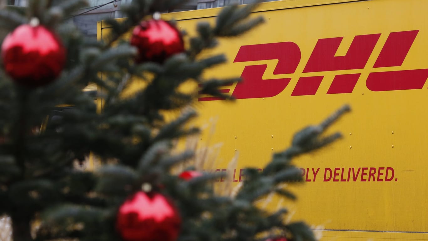 Ein DHL-Transporter hinter einem Weihnachtsbaum (Symbolbild): Der mutmaßliche Dieb hatte es vor allem auf Schmuck und Elektrogeräte abgesehen.