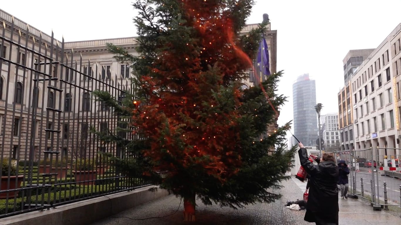 Aktivist der "Letzte Generation" besprüht einen Weihnachtsbaum vor dem Bundesrat: Am Nachmittag folgten Hausdurchsuchungen.