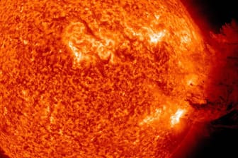 Ein Sonnensturm (rechts im Bild): Diese Aufnahme der Nasa zeigt, wie ein elektromagnetischer Sturm auf der Sonne aussieht.