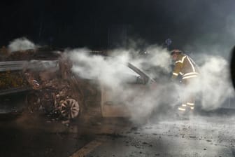 Das ausgebrannte Auto steht auf der A555: Die beiden Insassen kamen ums Leben.