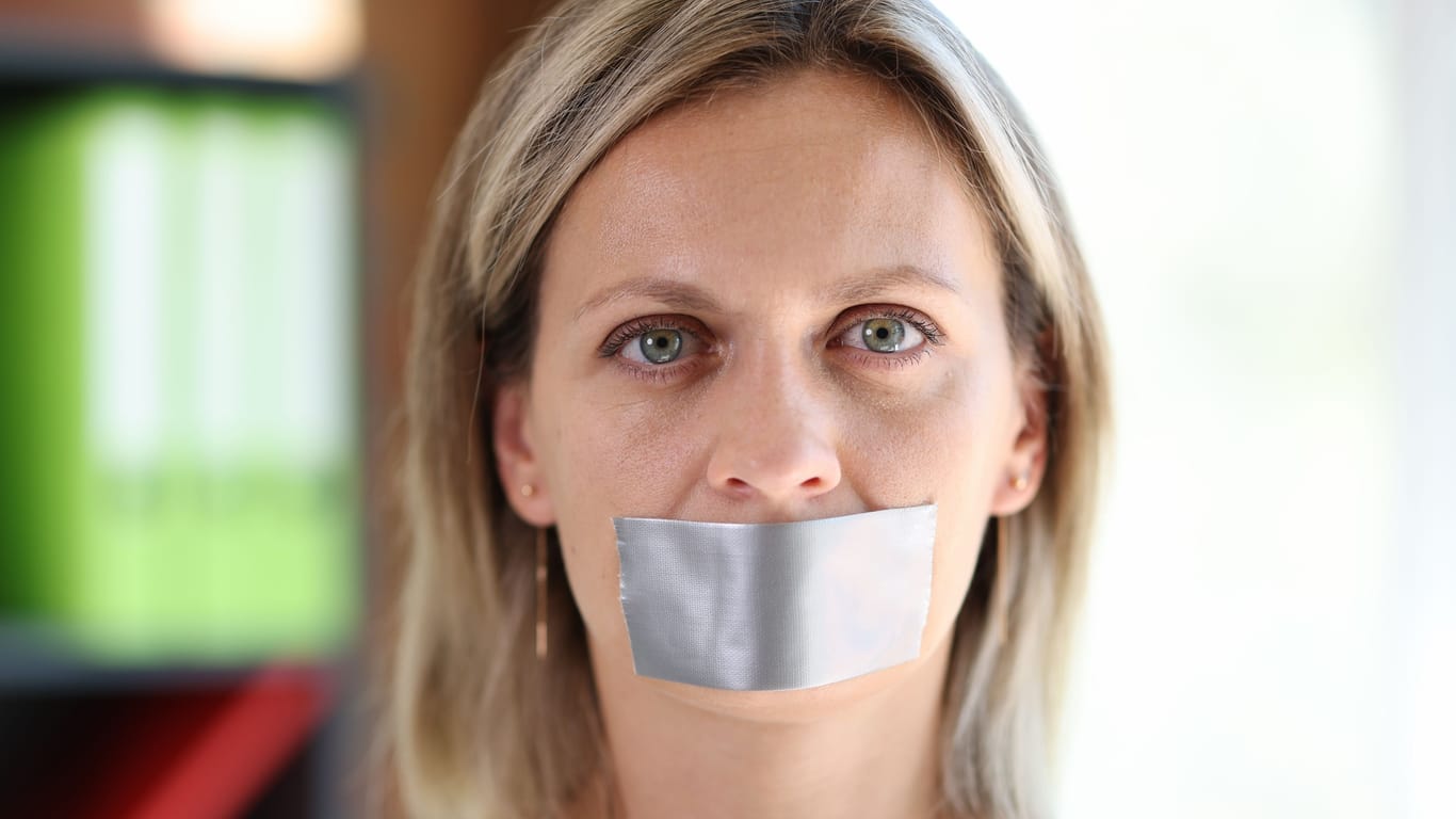 Eine Frau mit zugeklebtem Mund (Symbolbild): Viele Menschen finden, man kann seine Meinung nicht frei äußern.