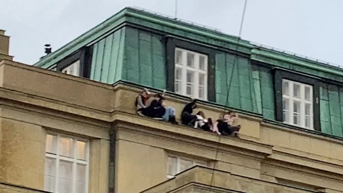 Menschen verstecken sich auf einem Dachvorsprung vor dem Schützen: