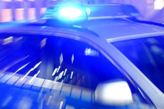 Ein Streifenwagen der Polizei steht mit eingeschaltetem Blaulicht auf der Straße