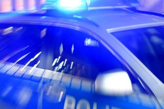 Ein Streifenwagen der Polizei steht mit eingeschaltetem Blaulicht auf der Straße