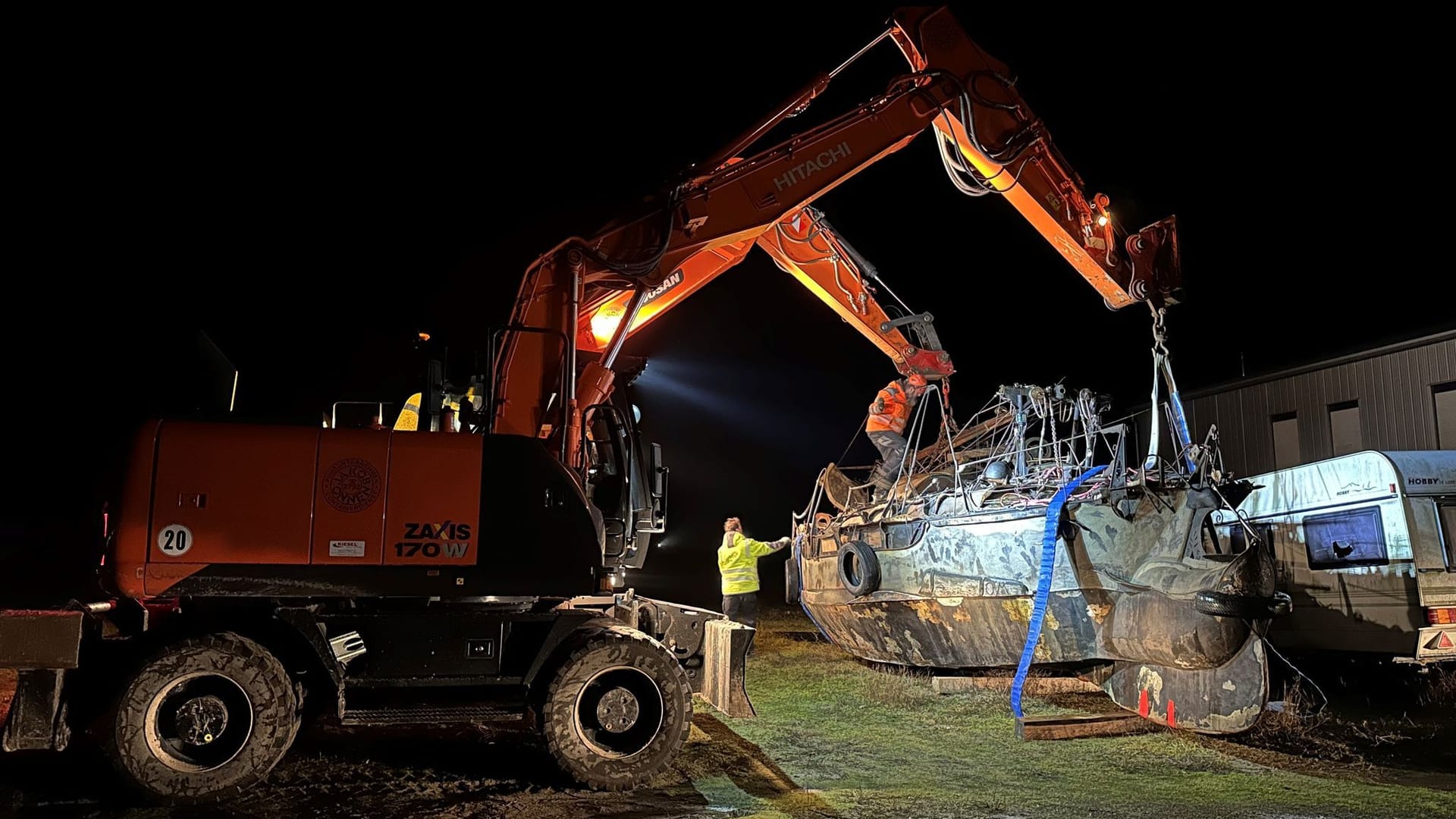Zwei Bagger heben das im Hafen von Norderney abgestellte Segelboot für einen geplanten Abtransport zum Festland an: Es war Anfang November auf der Insel gestrandet. Zwei Bagger heben das im Hafen von Norderney abgestellte Segelboot für einen geplanten Abtransport zum Festland an: Es war Anfang November auf der Insel gestrandet.
