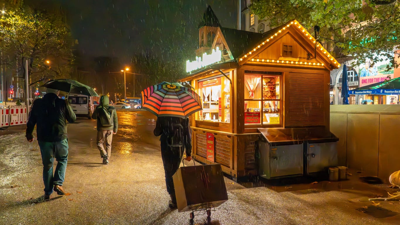Weihnachtsmarkt bei Regen (Symbolbild): Das Wetter wird zwar wärmer, aber auch regnerisch.