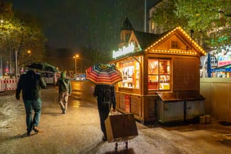 Weihnachtsmarkt bei Regen (Symbolbild): Das Wetter wird zwar wärmer, aber auch regnerisch.