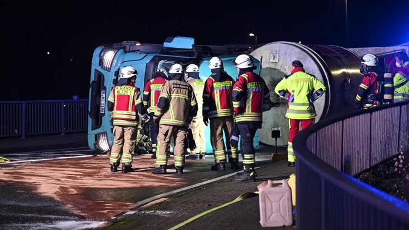 Einsatzkräfte vor dem umgekippten Lkw: Der Betonmischer war zuvor ins Schlinger geraten.