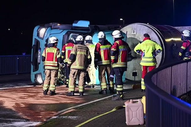 Einsatzkräfte vor dem umgekippten Lkw: Der Betonmischer war zuvor ins Schlinger geraten.