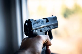 Ein Mann hält eine Pistole in der Hand (Symbolbild): Der mutmaßliche Täter kam in eine Fachklinik.