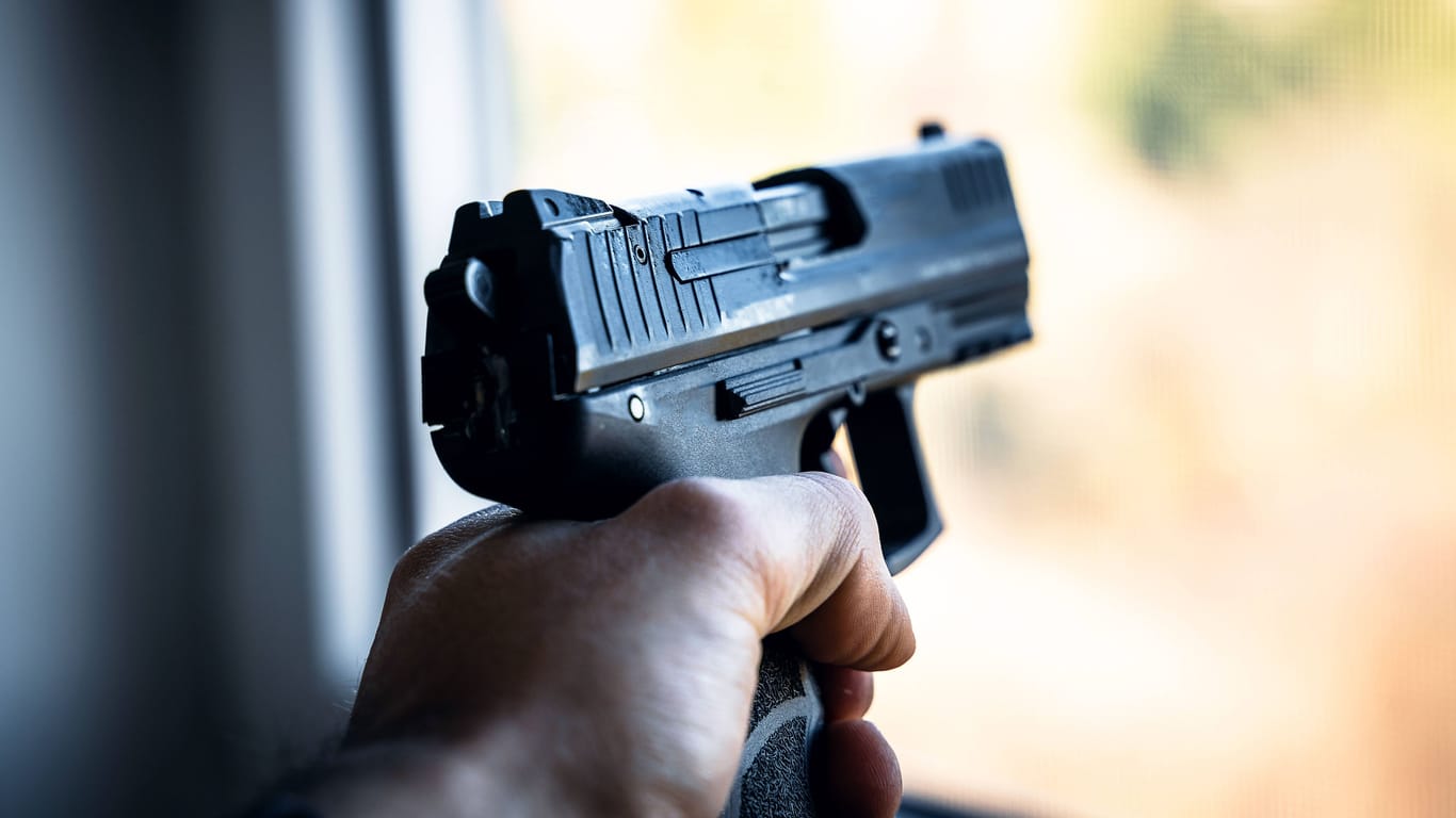 Ein Mann hält eine Pistole in der Hand (Symbolbild): Der mutmaßliche Täter kam in eine Fachklinik.