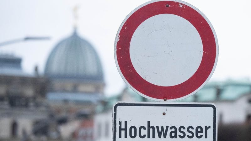 Ein Schild mit der Aufschrift "Hochwasser" steht am Terrassenufer. Die Hochwasserlage hat sich in Teilen Sachsens verschärft.