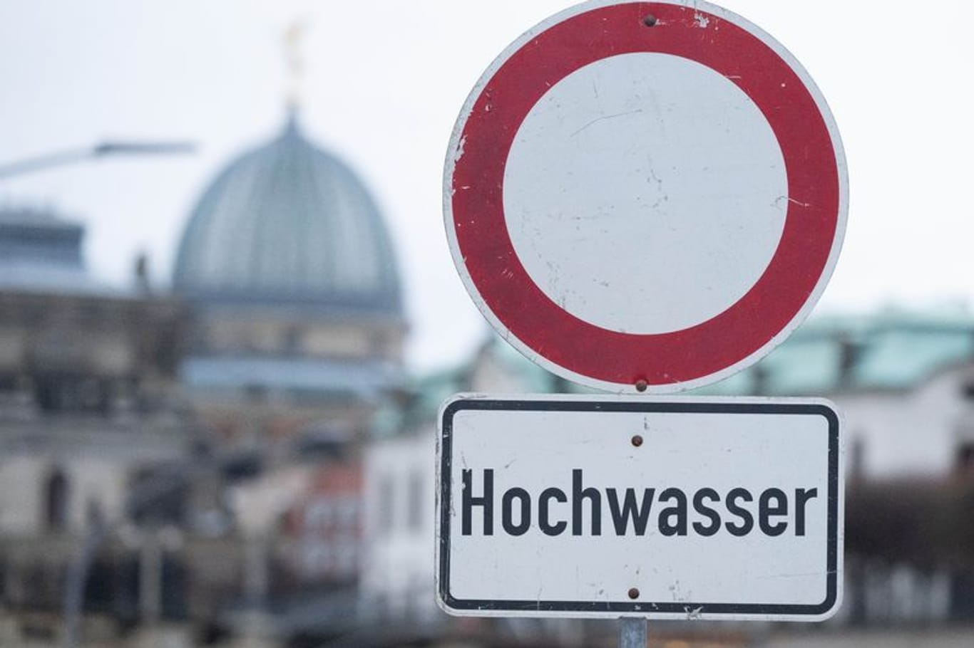 Ein Schild mit der Aufschrift "Hochwasser" steht am Terrassenufer. Die Hochwasserlage hat sich in Teilen Sachsens verschärft.