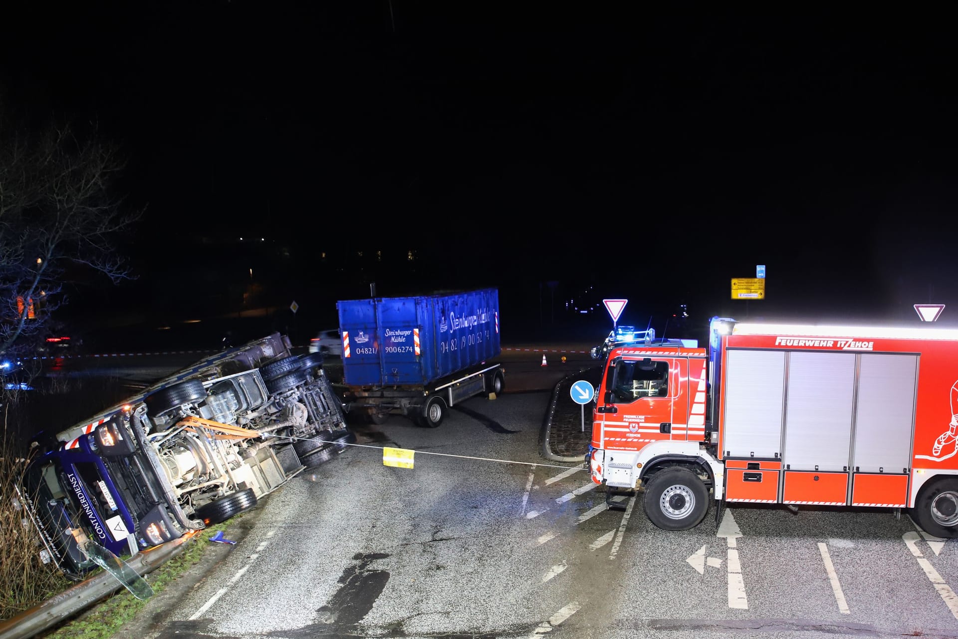 Ein Feuerwehrfahrzeug sichert den Lkw: Warum der Laster von der Straße abkam, ist noch unklar.