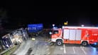 Ein Feuerwehrfahrzeug sichert den Lkw: Warum der Laster von der Straße abkam, ist noch unklar.