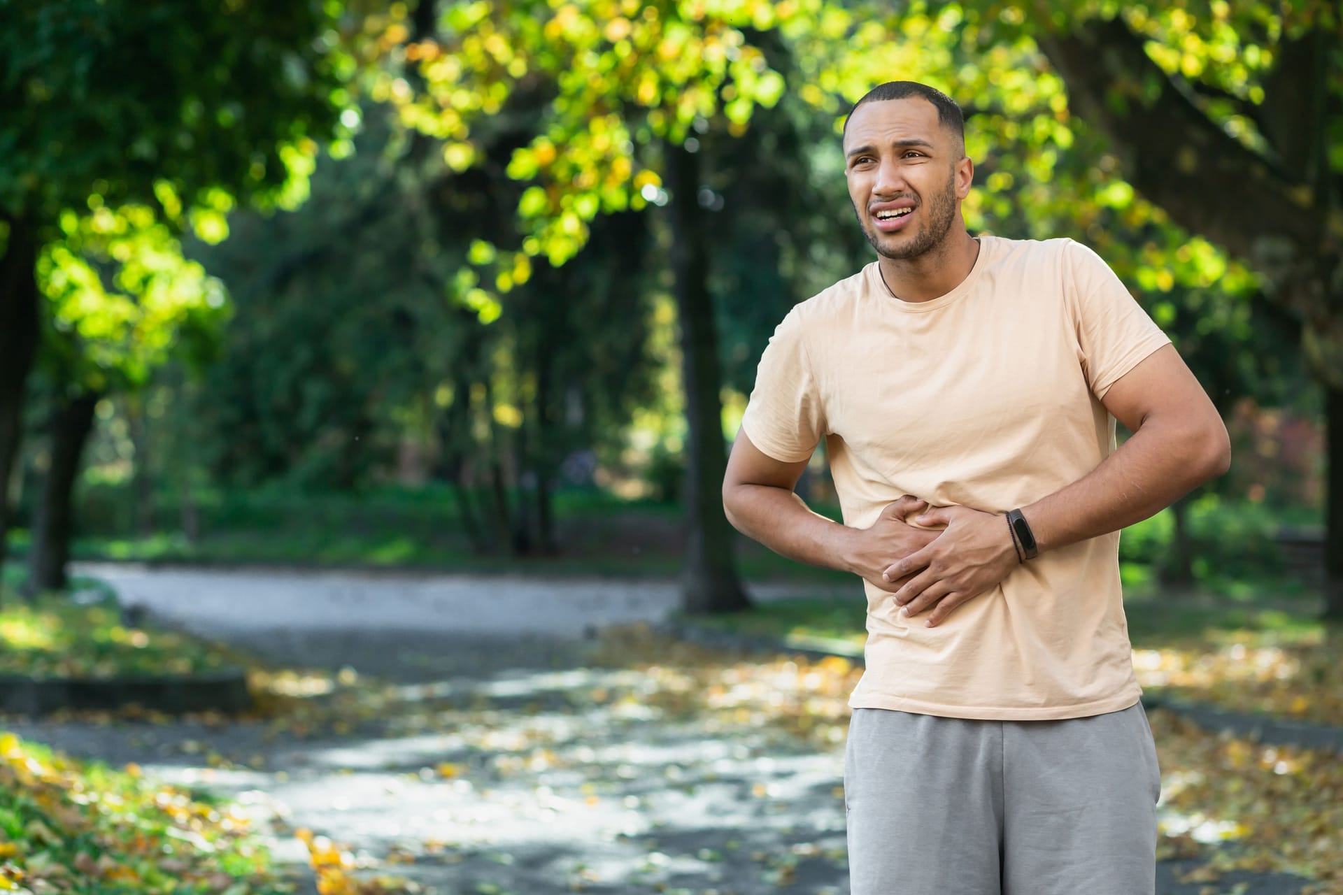 Mann mit Seitenstechen: Seitenstechen beim Joggen kann unangenehm sein, ist in der Regel jedoch harmlos.