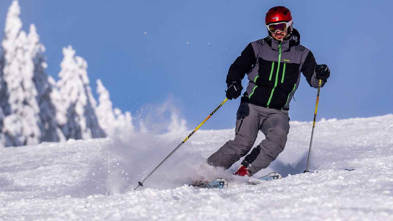 Ein Mann fährt Ski (Symbolbild): Am Wochenende dürfte es auf den Pisten in Bayern voll werden.