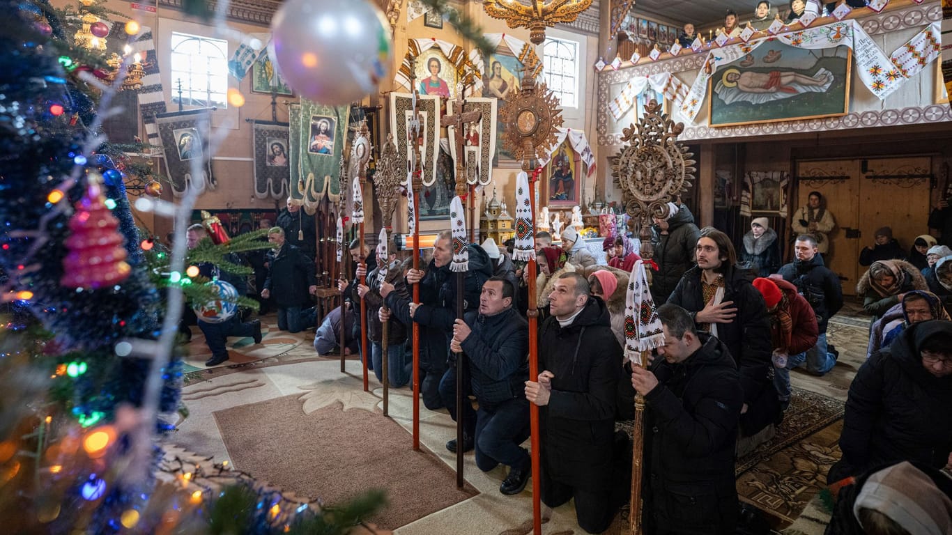 Heiligabend im ukrainischen Kryworiwnja: Menschen beten in einer Kirche während einer Weihnachtsfeier.