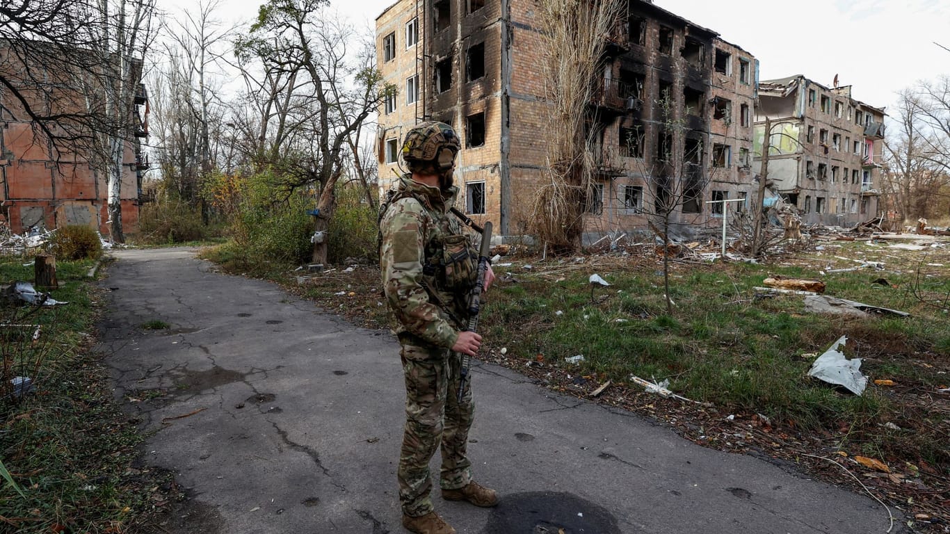 Ein ukrainischer Soldat steht vor Gebäuden, die von russischen Luftschlägen troffen wurden.