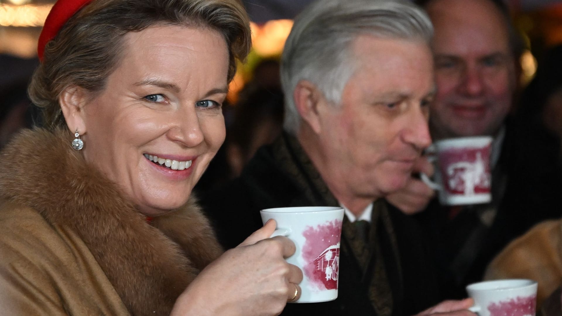König Philippe und Königin Mathilde von Belgien trinken auf dem Weihnachtsmarkt auf dem Neumarkt Glühwein.