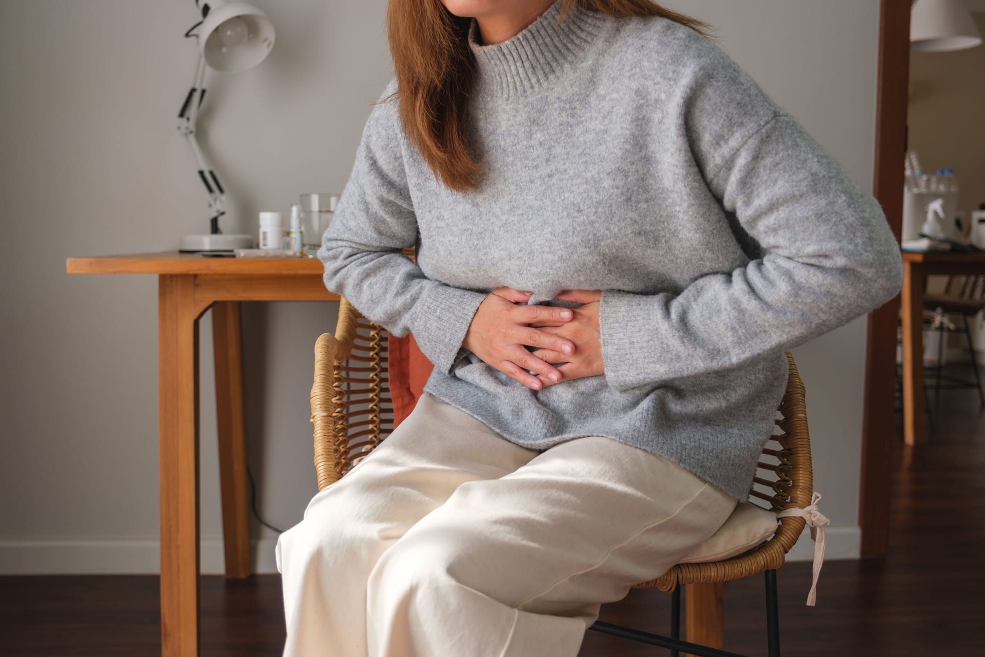 Eine Frau hält sich den Bauch vor Schmerzen.