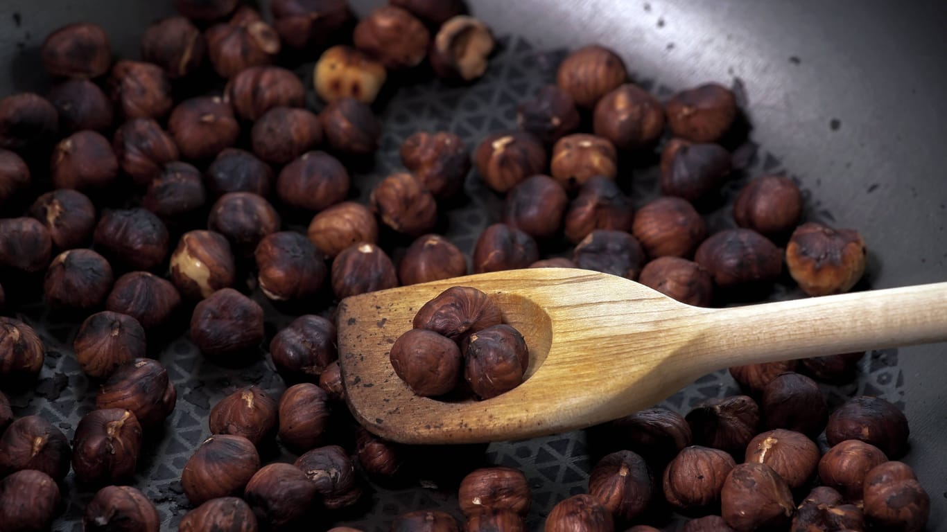 Haselnüsse rösten: Die Nüsse in einer beschichteten Pfanne ohne Öl scharf anrösten, bis die Haut schwarz wird und abplatzt.