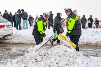 Polizisten schaufeln Schnee in Peking (Archivbild): In der chinesischen Hauptstadt war es viele Tage lang besonders kalt.