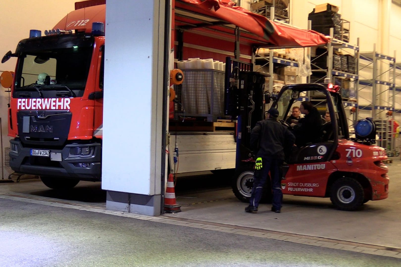 Feuerwehrleute beladen einen Lkw für den Transport des Hochwasserschutzsystems nach Oldenburg.