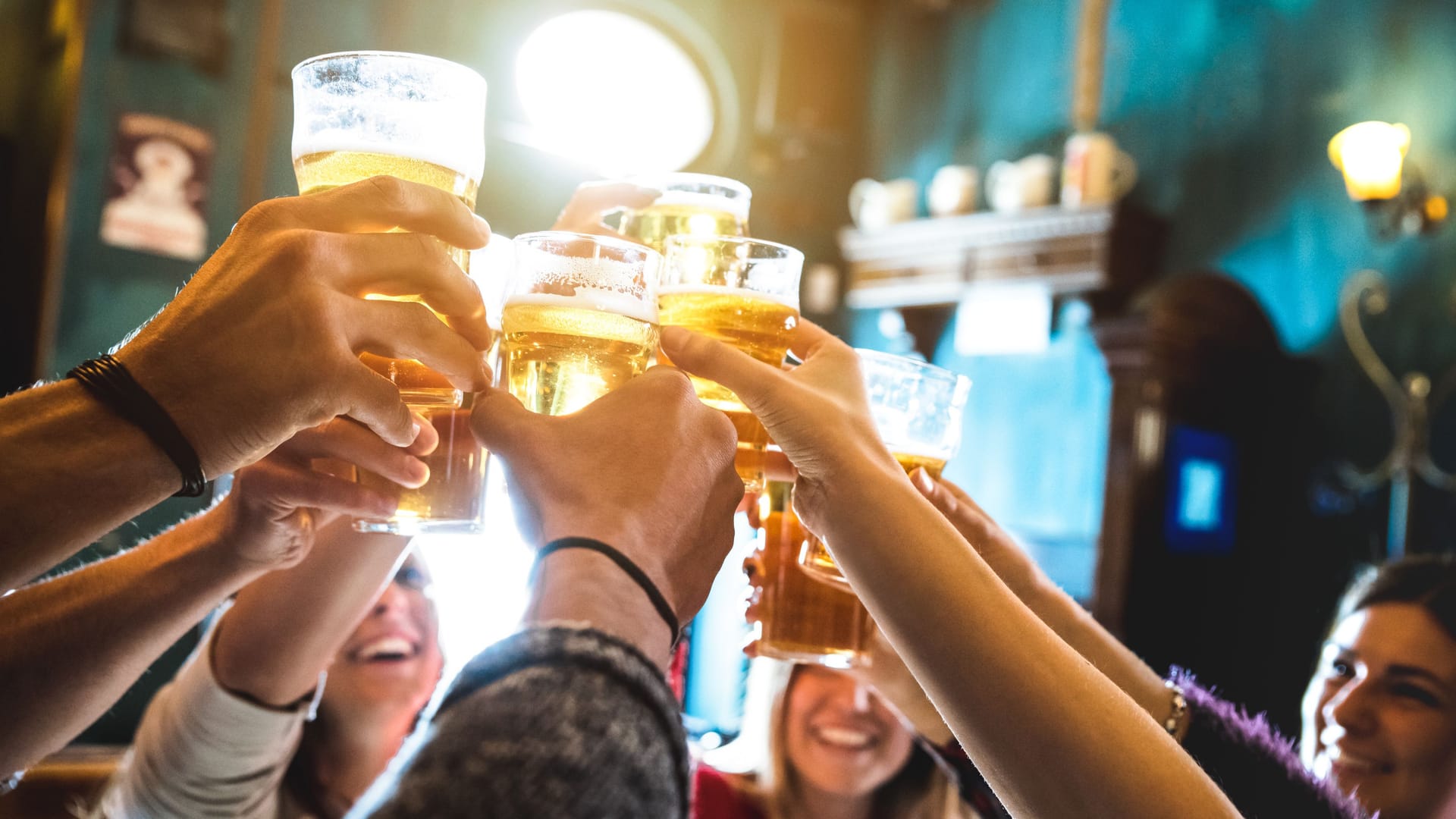 Mehrere Leute stoßen mit Bier an