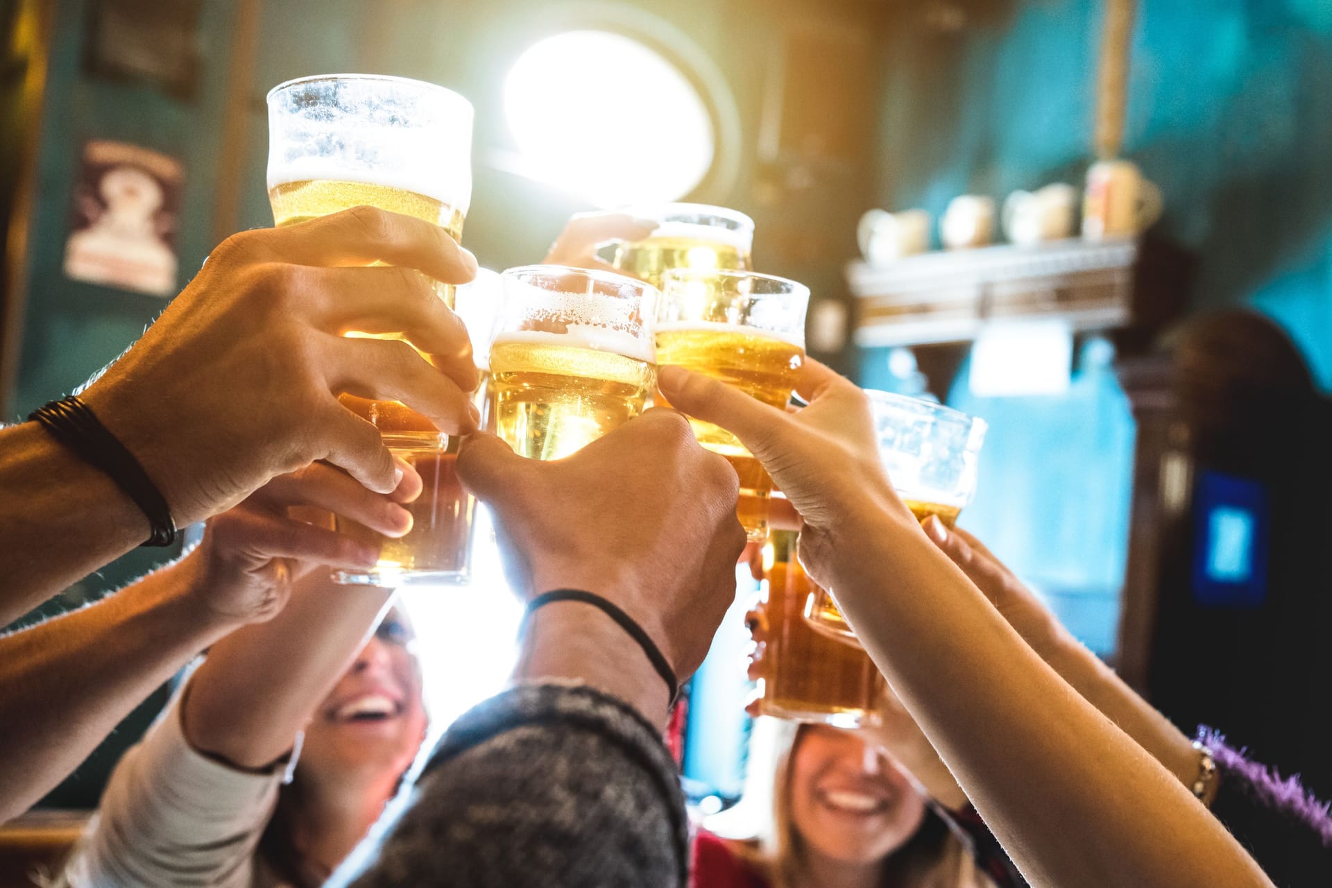 Mehrere Leute stoßen mit Bier an