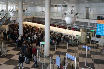 Passagiere stehen am Dienstag am Münchener Flughafen beim Check-in.