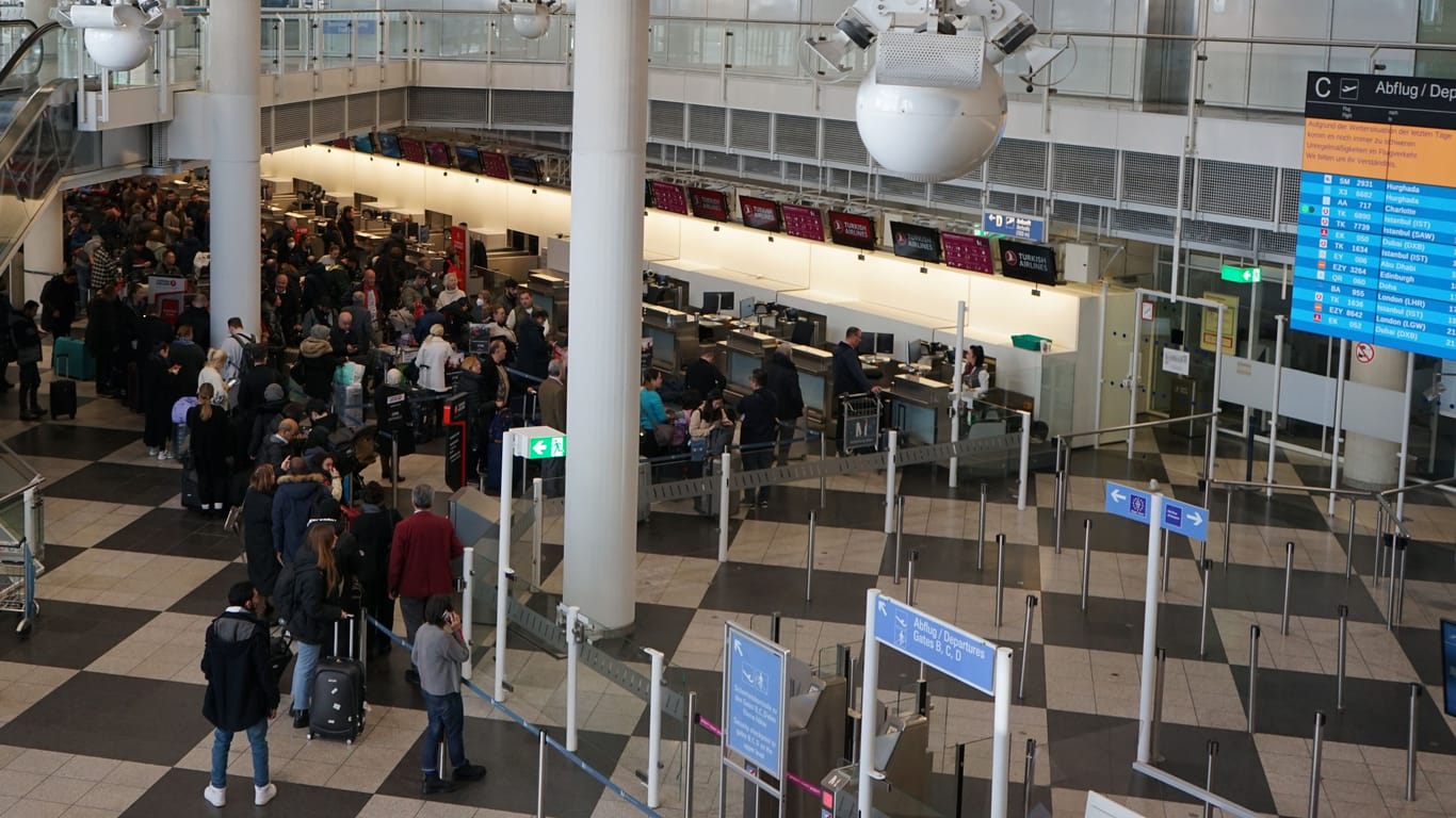 Passagiere stehen am Dienstag am Münchener Flughafen beim Check-in.