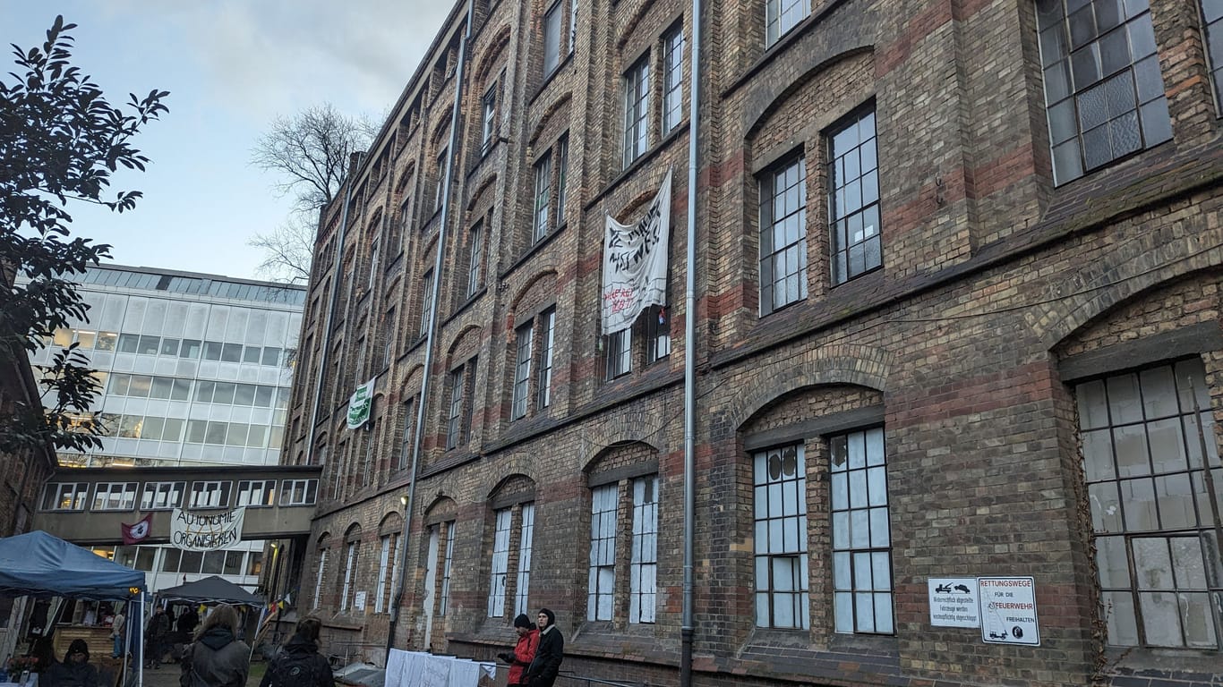 Ansicht aus dem Innenhof der Dondorf-Druckerei in Bockenheim. Hie und da stehen Aktivisten oder lehnen an der Ziegelstein-Fassade