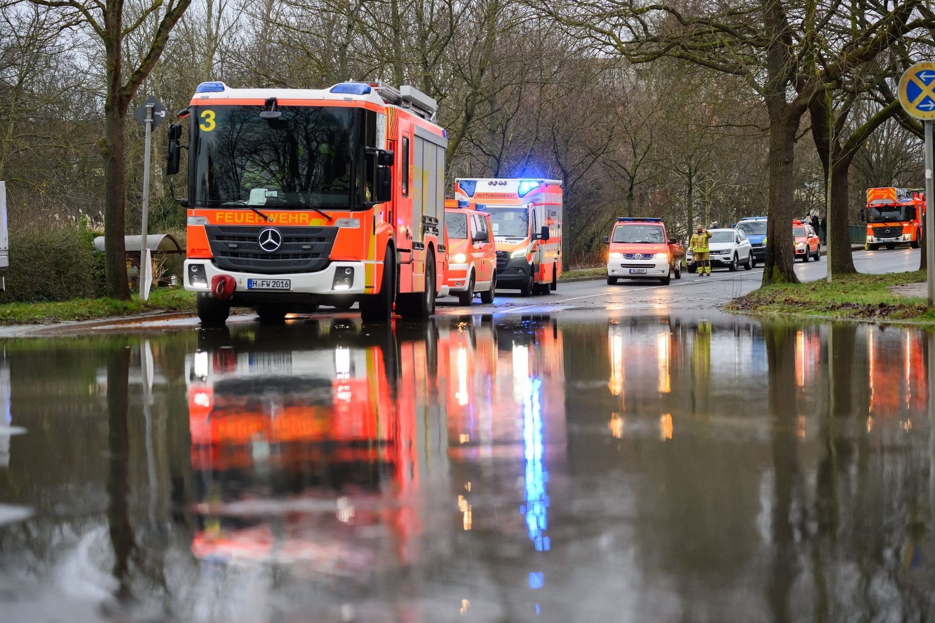 Hochwasser: Einsatzkräfte der Feuerwehr Hannover stehen bei einem Einsatz auf einer überfluteten Straße.