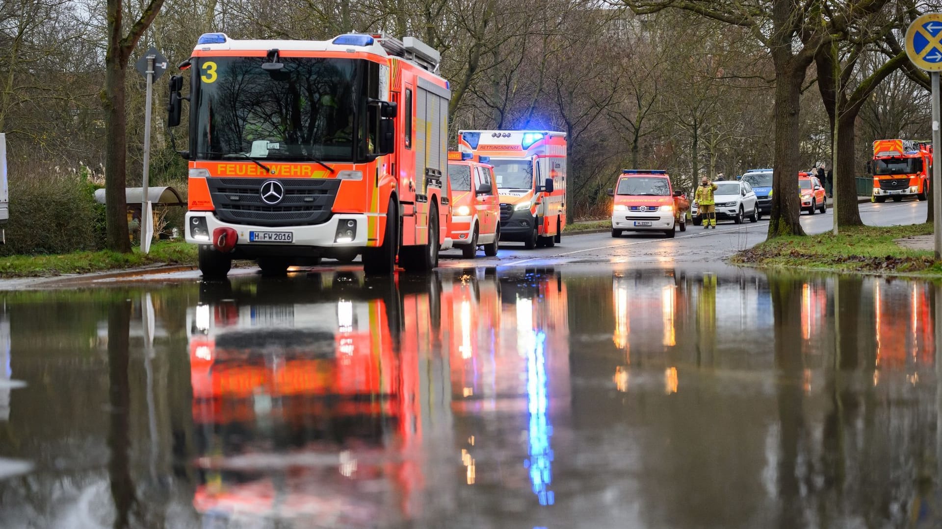 Hochwasser: Einsatzkräfte der Feuerwehr Hannover stehen bei einem Einsatz auf einer überfluteten Straße.