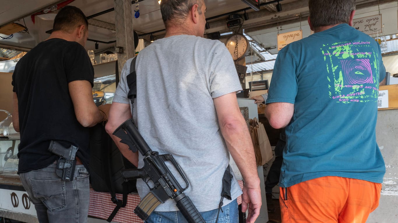 Männer stehen bewaffnet an einem Imbiss in der Stadt Shoresh.