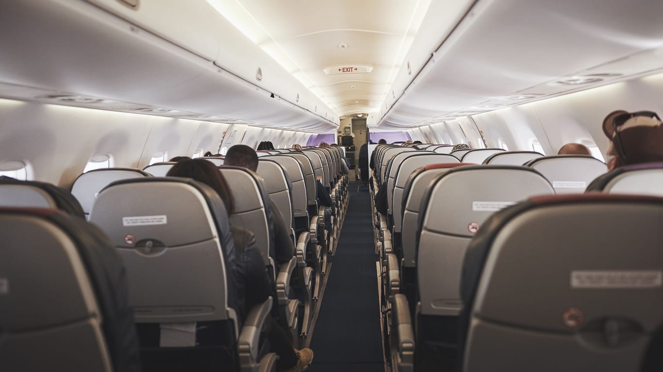 Everyone please remain seated. a empty aisle in an aeroplane.