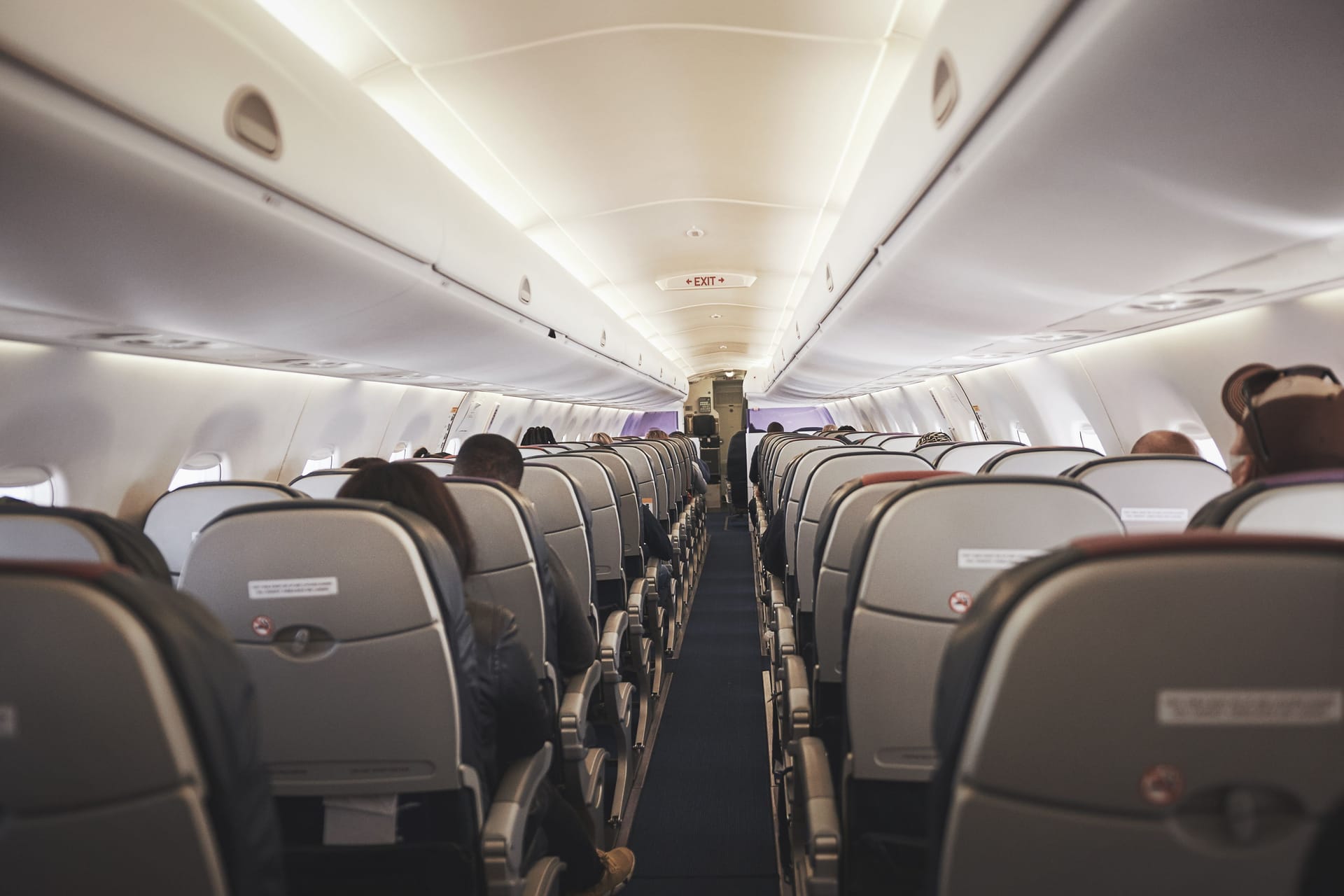 Everyone please remain seated. a empty aisle in an aeroplane.