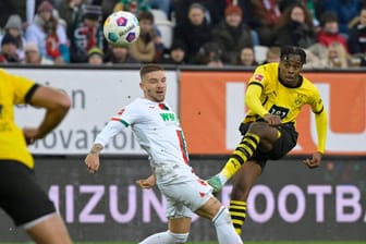 Jamie Bynoe-Gittens (r.) schießt aufs Tor: Beim Spiel des BVB in Augsburg kam es zu einem kuriosen Moment für die TV-Zuschauer.