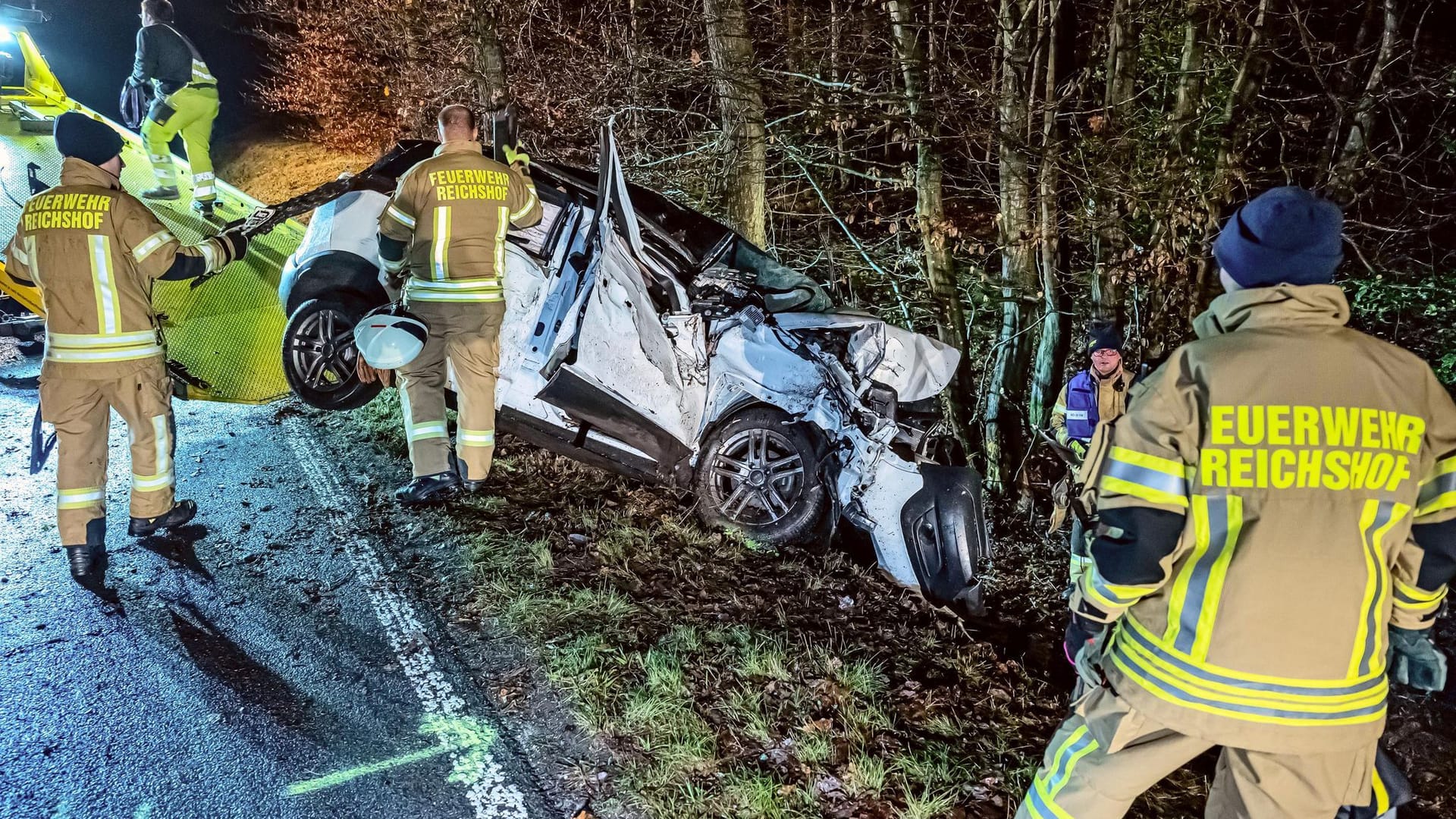 Feuerwehrleute helfen beim Abschleppen des Wracks nach einem Unfall im Oberbergischen Kreis.