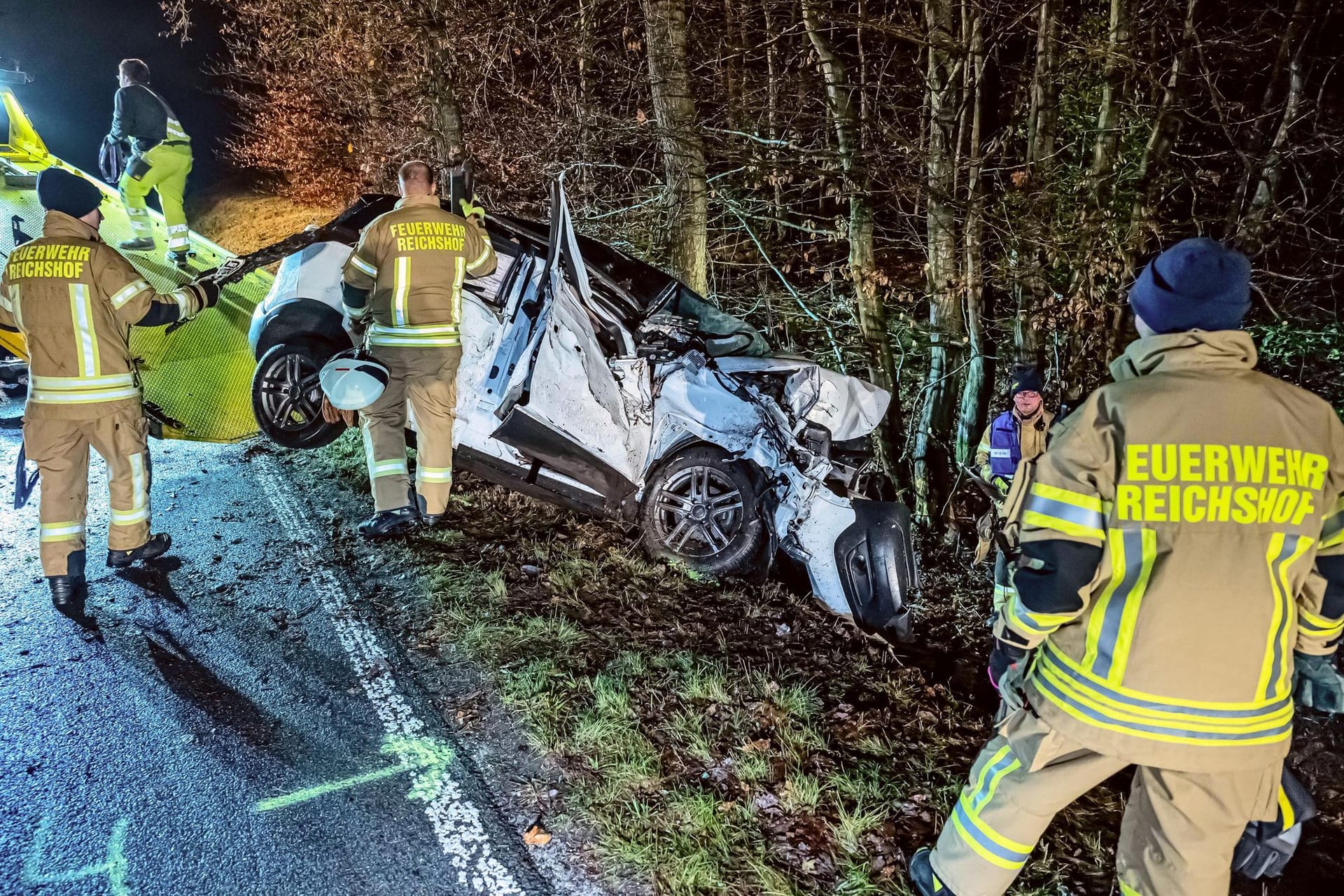 Feuerwehrleute helfen beim Abschleppen des Wracks nach einem Unfall im Oberbergischen Kreis.